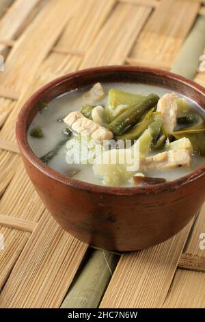 Sayur Lodeh oder Gemüse mit Kokosmilchsuppe. Traditionelle indonesische kulinarische Gerichte aus Java in einer traditionellen Schüssel, serviert auf dem Bamboo Table. Selektiv Stockfoto