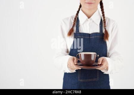 Beschnittenes Bild einer Barista, die eine große Tasse Cappuccino für den Gast gab Stockfoto