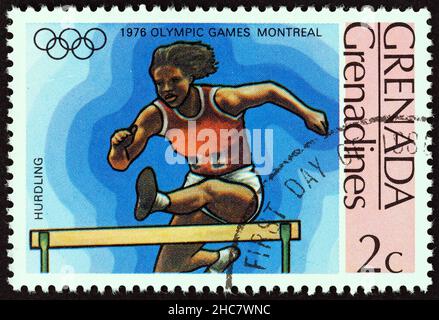 GRENADINEN VON GRENADA - UM 1976: Eine in Grenada gedruckte Marke aus der Ausgabe 'Olympic Games, Montreal' zeigt Hurdling, um 1976. Stockfoto