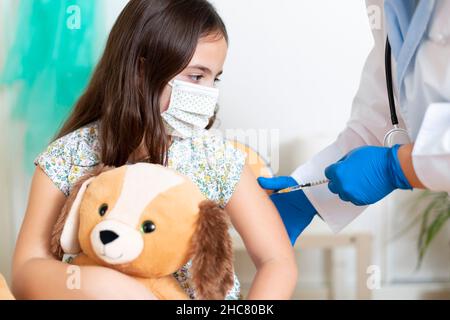 Kleines kaukasisches Kind, das gegen das Covid-19-Virus geimpft wird. Impfkonzept für Kinder. Stockfoto