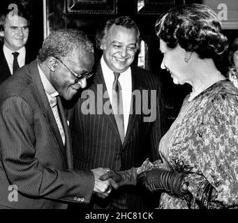 File photo dated 09/03/87 of Queen Elizabeth II Meeting the anglikanischen Erzbischof von Kapstadt, Desmond Tutu at a Commonwealth Day Reception at Marlborough House, London, with Sir Shridath Ramphal, Secretary-General of the Commonwealth, looking on. Desmond Tutu, der mit dem Friedensnobelpreis ausgezeichnete Aktivist für Rassengerechtigkeit und LGBT-Rechte, ist im Alter von 90 Jahren verstorben. Seit 2015 war er mehrere Male im Krankenhaus behandelt worden, nachdem er 1997 mit Prostatakrebs diagnostiziert worden war. Ausgabedatum: Sonntag, 26. Dezember 2021. Stockfoto