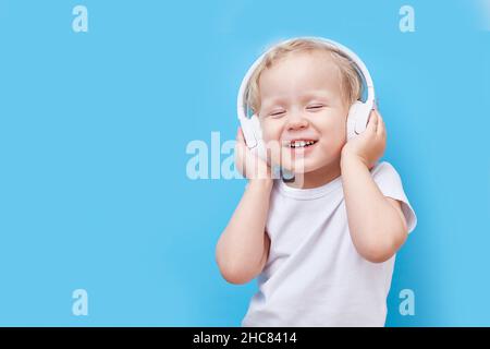 Kopfhörer auf dem Kopf des Kindes. Hört Musik und Tänze. Speicherplatz kopieren Stockfoto