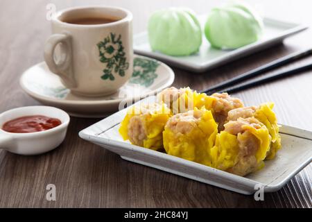 SIU Mai - Chinesische gedünstete Schweineknödel in Bambusdampfern. Stockfoto