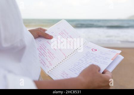Notizbuch, Frau liest Ihre Notizen in der Nähe des Meeres Stockfoto