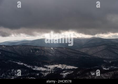 Schneebedeckter Wald in den Bergen an einem bewölkten Tag, Bieszczady-Gebirge, Polen Stockfoto