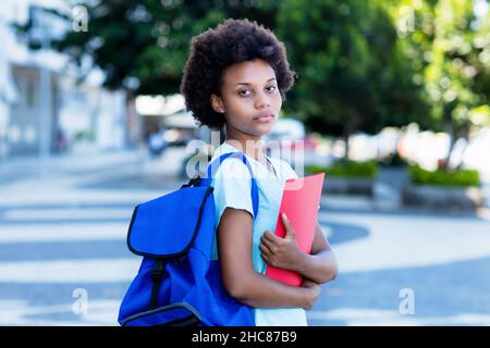 Junge afroamerikanische Studentin in der Stadt zu Fuß zur Universität im Sommer Stockfoto