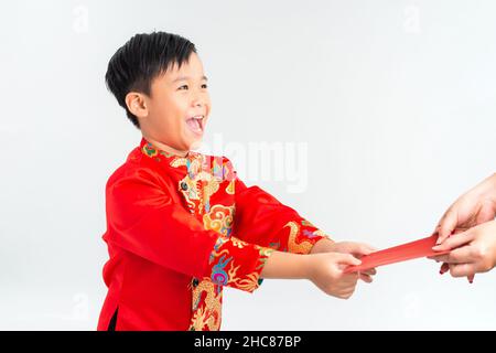 Vietnamesischer Junge in einem roten AO dai erhielt einen Umschlag. Mondneujahreskonzept. Stockfoto