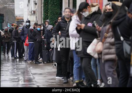 Im Kaufhaus Selfridges in der Oxford Street in London stehen die Käufer Schlange, damit sich die Türen für den Beginn der Verkäufe am zweiten Weihnachtsfeiertag öffnen. Laut einer Umfrage werden die Verbraucher von zu Hause aus einkaufen, aber nach Weihnachten mehr in den Verkäufen ausgeben als in den Vorjahren, was ein beruhigendes Zeichen für Online-Händler ist. Bilddatum: Sonntag, 26. Dezember 2021. Stockfoto