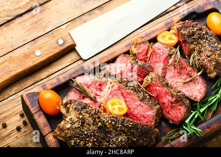 Gegrillte Rindersteaks mit Kumquat auf Küchentafel.Steak mittel selten Stockfoto