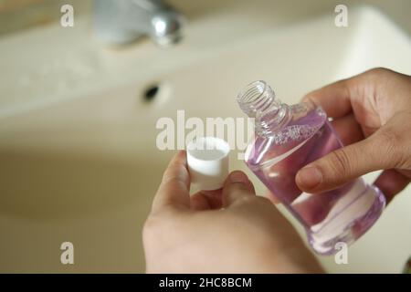 Frauen halten einen Behälter mit Mundwasser in der Hand Stockfoto