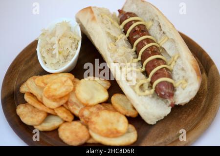 Deutsche Würstchen (Bockwurst) Hotdog mit Senfrolle und Chips Stockfoto