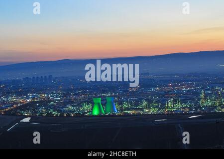 Kühltürme der Ölraffinerie, nachts mit farbigen Lichtern beleuchtet. Fotografiert in Israel, Bucht von Haifa bei Nacht Stockfoto