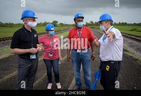 NASA James Webb Space Telescope Program Scientist Eric James Left, NASA James Webb Space Telescope Program Manager Jeanne Davis, NASA Program Director für das James Webb Space Telescope Greg Robinson, Und der Vizepräsident von Arianespace für Französisch-Guayana, Bruno Gérard, rechts, spricht, während sie auf die Arianespace-Ariane-5-Rakete mit dem James Webb Space Telescope der NASA warten, die am Donnerstag, den 23. Dezember 2021, im europäischen Weltraumbahnhof auf die Startrampe rollt. Das Weltraumzentrum Guayana in Kourou, Französisch-Guayana. Das James Webb Weltraumteleskop (manchmal auch JWST oder Webb genannt) ist ein großes Infrarotteleskop mit Stockfoto