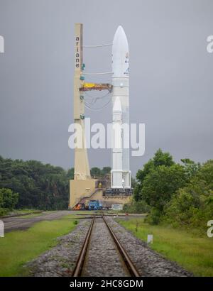 Die Ariane 5-Rakete von Arianespace mit dem James Webb Space Telescope der NASA wird am Donnerstag, den 23. Dezember 2021, im europäischen Weltraumbahnhof ausgerollt. Das Weltraumzentrum Guayana in Kourou, Französisch-Guayana. Das James Webb Weltraumteleskop (manchmal auch JWST oder Webb genannt) ist ein großes Infrarotteleskop mit einem Primärspiegel von 21,3 Fuß (6,5 Meter). Das Observatorium wird jede Phase der kosmischen Geschichte untersuchen – von unserem Sonnensystem bis zu den entferntesten beobachtbaren Galaxien im frühen Universum. Obligatorische Gutschrift: Bill Ingalls/NASA über CNP /MediaPunch Stockfoto