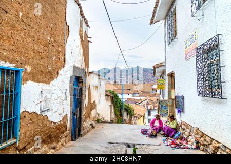 Peruanische Frauen sitzen auf der Straße und verkaufen traditionelle peruanische Webtextilien in San Blas, Cusco, Sacred Valley, Peru Stockfoto