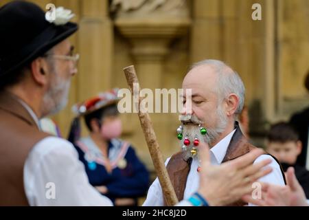 Gloucester, Großbritannien. 26th Dez 2021. Morris Men und Mummers treten vor der mittelalterlichen Kathedrale auf. Mit Figuren wie St. George und der Drache markiert die Mummers das Ende des alten Jahres und den Beginn des neuen. Der Morris ist eine Form des Volkstanzes, der zwischen den britischen Regionen leicht variiert, aber die Glocken scheinen konsistent zu sein. Kredit: JMF Nachrichten/Alamy Live Nachrichten Stockfoto