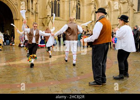 Gloucester, Großbritannien. 26th Dez 2021. Morris Men und Mummers treten vor der mittelalterlichen Kathedrale auf. Mit Figuren wie St. George und der Drache markiert die Mummers das Ende des alten Jahres und den Beginn des neuen. Der Morris ist eine Form des Volkstanzes, der zwischen den britischen Regionen leicht variiert, aber die Glocken scheinen konsistent zu sein. Kredit: JMF Nachrichten/Alamy Live Nachrichten Stockfoto