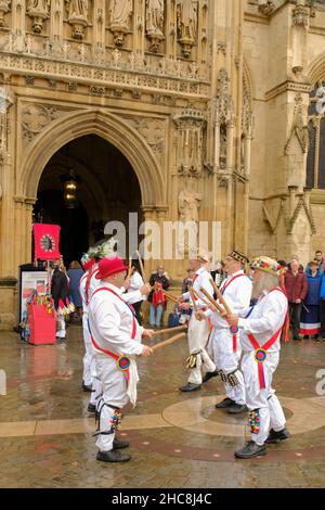 Gloucester, Großbritannien. 26th Dez 2021. Morris Men und Mummers treten vor der mittelalterlichen Kathedrale auf. Mit Figuren wie St. George und der Drache markiert die Mummers das Ende des alten Jahres und den Beginn des neuen. Der Morris ist eine Form des Volkstanzes, der zwischen den britischen Regionen leicht variiert, aber die Glocken scheinen konsistent zu sein. Kredit: JMF Nachrichten/Alamy Live Nachrichten Stockfoto