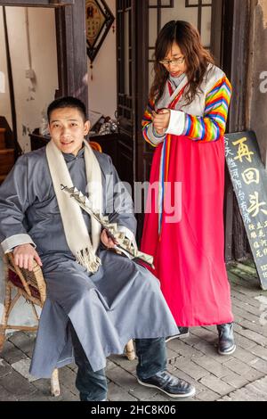 Der Mann in traditioneller Tracht wird auf einer Straße im alten Wasserdorf Xitang, China, fotografiert Stockfoto