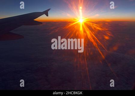 Sonnenuntergang über der Wolkenbasis, im Winter von einem Passagierflugzeug auf einem Flug von München nach Zypern aus gesehen Stockfoto