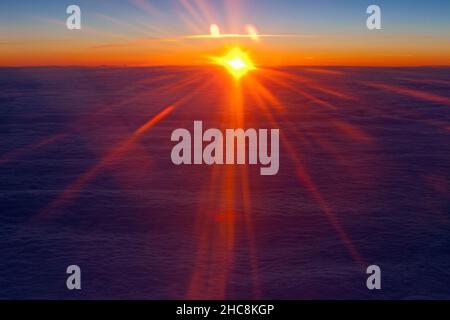 Sonnenuntergang über der Wolkenbasis, im Winter von einem Passagierflugzeug auf einem Flug von München nach Zypern aus gesehen Stockfoto