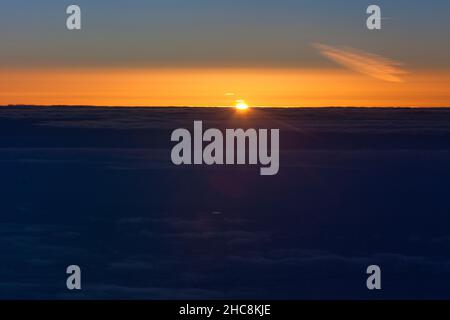 Sonnenuntergang, von einem Flugzeug aus gesehen, über den Wolken auf einem Flug von München nach Zypern Stockfoto