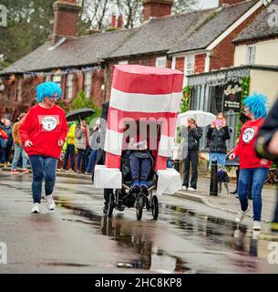 East Hoathly, Großbritannien. 26th Dez 2021. Boxing Day Kinderwagen: Teams Rennen durch das Dorf East Hoathly in East Sussex und sammeln Spenden für lokale Wohltätigkeitsorganisationen und die Carnival Society. Die jährliche Veranstaltung beginnt und endet im Kings Head Pub im Zentrum des Dorfes. Kredit: Jim Holden/Alamy Live Nachrichten Stockfoto