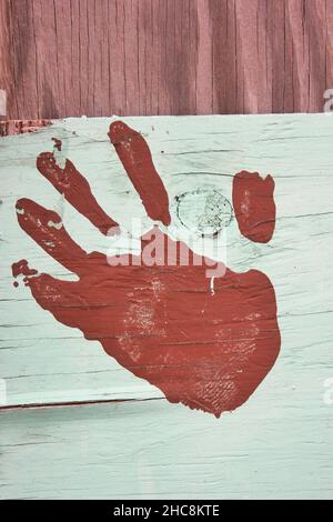 Alte Holzdiele mit dem Handdruck einer linken Hand bemalt. Stockfoto