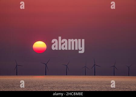 Sonnenuntergang über dem Offshore-Windpark Gwynt-y-Môr, Colwyn Bay, Nordwales Stockfoto