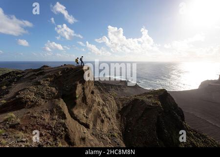 Mutter und Sohn stehen auf einem Aussichtspunkt über dem Vulkan Capelinhos und dem Leuchtturm, Ponta dos Capelinhos, Faial, den Azoren, Portugal Stockfoto