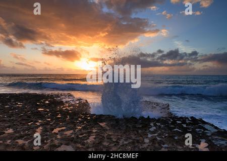 Sonnenuntergang und Wellen, die im Winter auf die felsige Küste stürmen, Halbinsel Akamas, Insel Zypern, östliches Mittelmeer Stockfoto