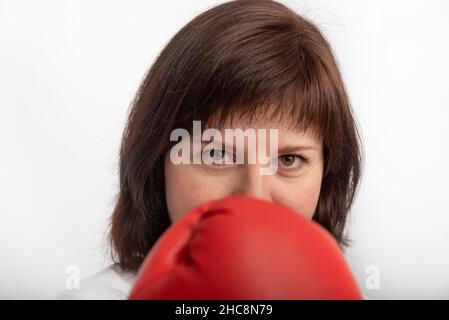 Nahaufnahme Porträt von dunkelhaarigen Mädchen in Boxhandschuhen auf weißem Hintergrund. Frauenrechte Veranstaltungskonzept Stockfoto