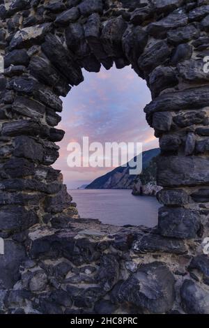 Felsige Berge an der Küste durch Steinbogenfenster gesehen. Italien, Ligurien, Portovenere Stockfoto