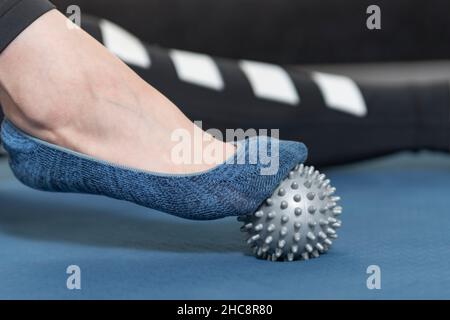 Mädchen mit Massage-Tool für Zehe Massage. Nahaufnahme. Trainingsgeräte für Selbstmaskierung. Myofaszialkugel. Stockfoto