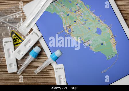 Covid-Heimtests liegen auf einem Tisch neben einer Karte von Florida Stockfoto