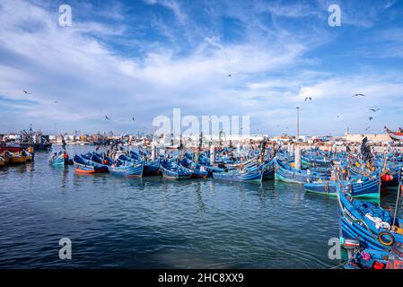 Blaue Fischerboote aus Holz vor dem bewölkten Himmel am Yachthafen vor Anker Stockfoto