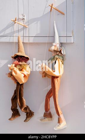 Zwei traditionelle griechische Handpuppen hängen an einer Wand im Dorf Oia in Griechenland Stockfoto