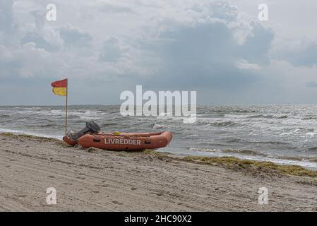 Gummiboot und eine rote und gelbe Flagge am Strand, was bedeutet, dass es Rettungsschwimmer überwacht, Karrebæksminde, Dänemark, 9. August 2021 Stockfoto