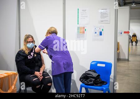 Ein Tropfen im Covid Vaccine Booster Center im Yorkshire Event Center, Harrogate, Yorkshire. Seit Beginn der Booster-Kampagne hat das Zentrum über einen Zeitraum von fünf Tagen 6613 Booster-Jabs adminsitoriert. Bethany Wrigglesworth erhält ihren Covid Booster-Impfstoff. Stockfoto