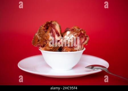 Stück Kirschkuchen auf rotem Hintergrund. Stockfoto