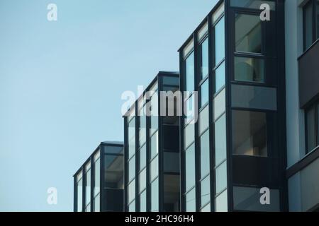 Gläsernes Gebäude mit tiefem Sichtwinkel am blauen Himmel, minimalistische Architektur Stockfoto