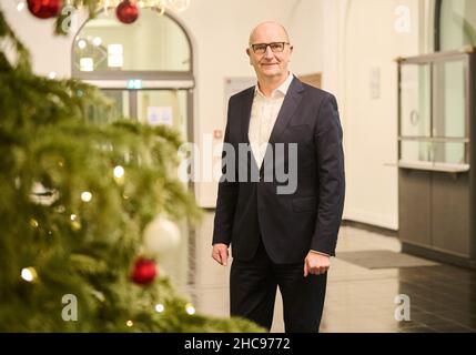 Potsdam, Deutschland. 22nd Dez 2021. Dietmar Woidke (SPD), Ministerpräsident des Landes Brandenburg, steht hinter dem Weihnachtsbaum im Foyer der Staatskanzlei. Quelle: Annette Riedl/dpa/Alamy Live News Stockfoto