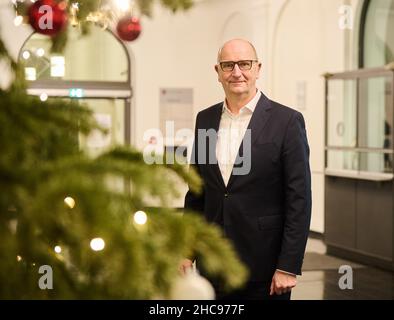 Potsdam, Deutschland. 22nd Dez 2021. Dietmar Woidke (SPD), Ministerpräsident des Landes Brandenburg, steht hinter dem Weihnachtsbaum im Foyer der Staatskanzlei. Quelle: Annette Riedl/dpa/Alamy Live News Stockfoto