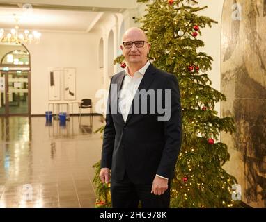 Potsdam, Deutschland. 22nd Dez 2021. Dietmar Woidke (SPD), Ministerpräsident des Landes Brandenburg, steht vor dem Weihnachtsbaum im Foyer der Staatskanzlei. Quelle: Annette Riedl/dpa/Alamy Live News Stockfoto