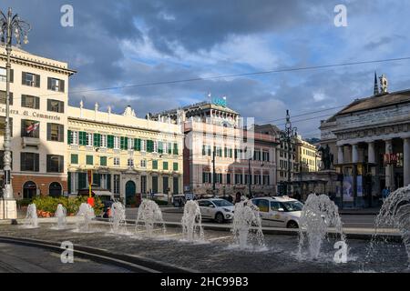 Blick auf die Piazza De Ferrari mit den Wasserspielen des Brunnens und das Theater Teatro San Felice im Hintergrund an einem bewölkten Herbsttag Stockfoto