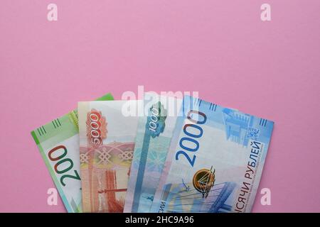 Russische Rubel auf einem rosa Hintergrund. Tausend Banknoten und verschiedene Münzen. Speicherplatz kopieren. Stockfoto