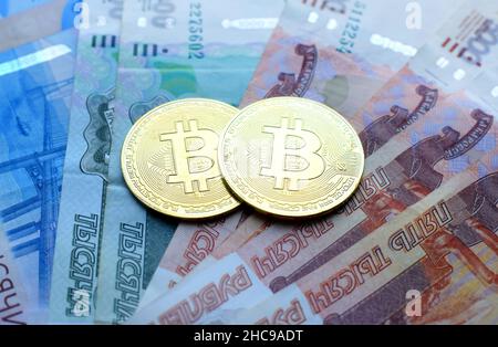 Metall glänzende Bitcoin Krypto-Währungsmünzen auf Rubel-Banknoten. Konzept für elektronisches Geld. Stockfoto