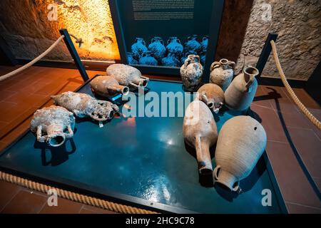 26. August 2021, Andriake, Türkei: Die antike griechische Amphore wurde von Töpfern aus Ton hergestellt und zum Transport von Olivenöl und Wein verwendet. Beleuchtete Ausstellung Stockfoto