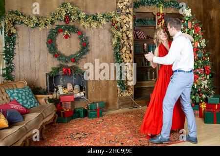 Schönes Paar tanzen im dekorierten Wohnzimmer von weihnachtsbaum feiern Neujahr Party Stockfoto