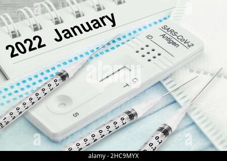 Kalender 2022 Januar mit 3 Injektionen und Corona Rapid Antigen Test und FFP2 Maske Stockfoto